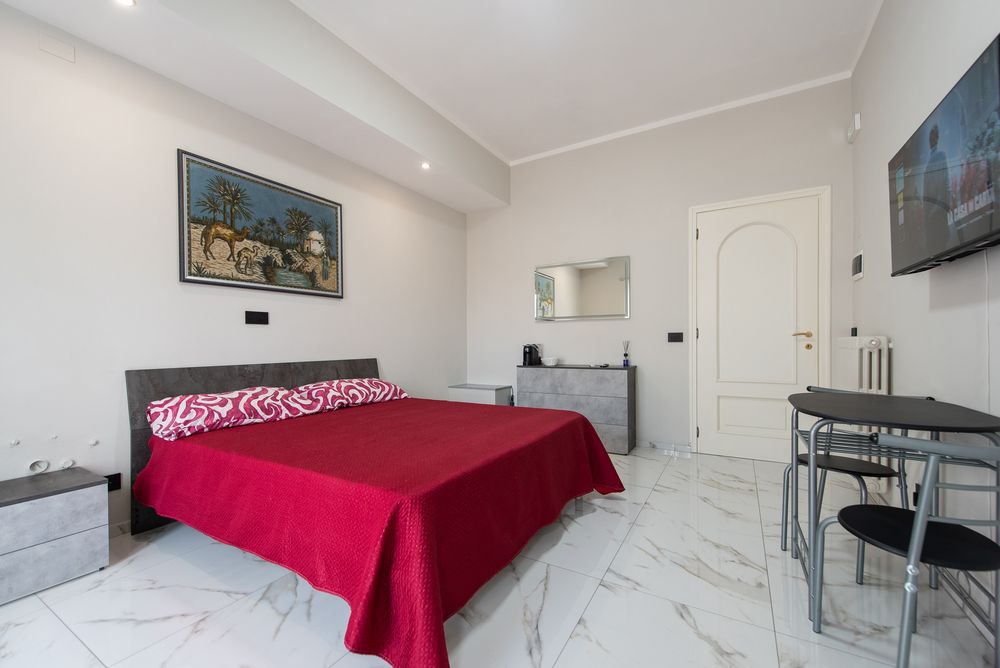Camera Oasi: letto matrimoniale con arazzo raffigurante un'oasi