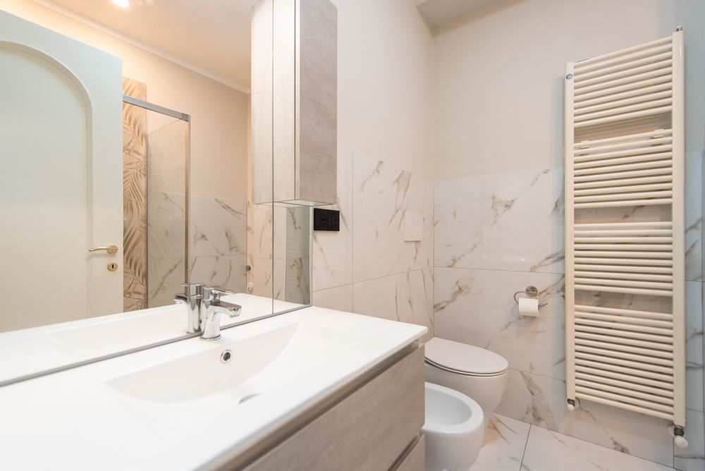 Bagno con doccia e piastrelle a motivo foglia di palma