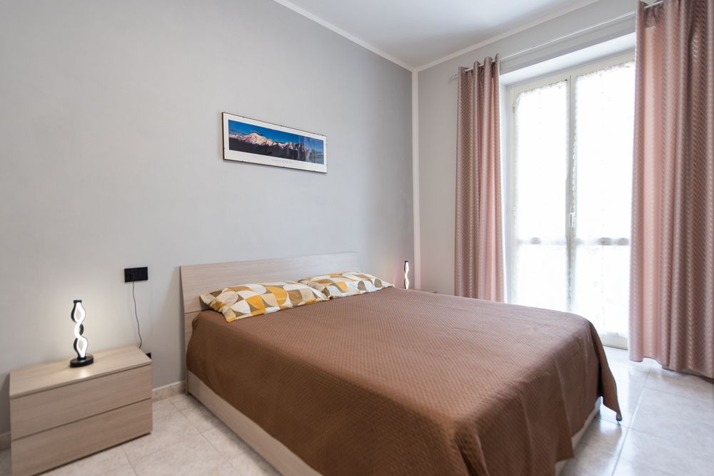Camera Alpina: letto matrimoniale con tende rosa antico e quadro del Monte Bianco